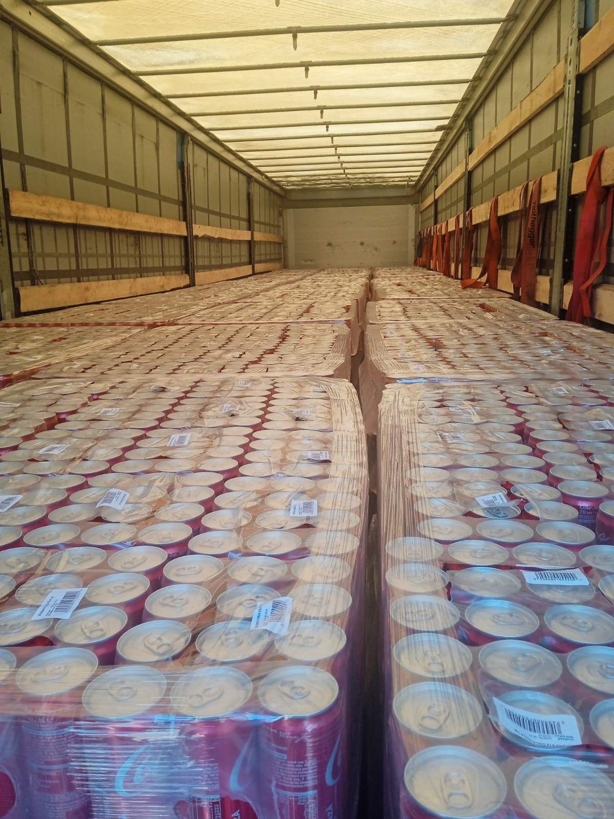 Vue intérieure remorque chargement complet canettes Coca-Cola