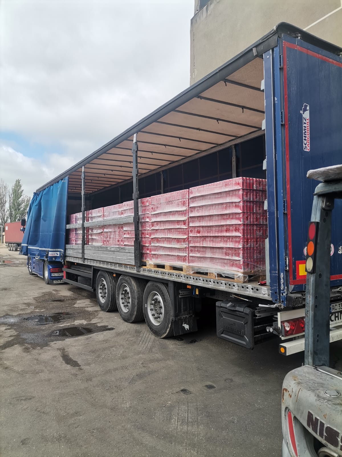 Semi-remorque bâchée chargement Coca-Cola palettes vue latérale